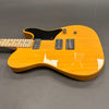 Electric guitar with natural wood finish, black pickguard, dual humbucker pickups, maple neck, and chrome hardware on gray background