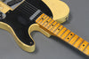Close-up of vintage cream electric guitar body and maple fretboard with black pickguard and single-coil pickup showing wear and aging details