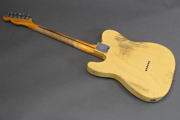 Vintage yellow relic electric guitar with maple neck and six tuning pegs, worn finish on back body and neck plate screws visible on gray background