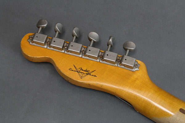 Back of Fender Custom Shop guitar headstock with six vintage tuners on gray background