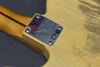 Close-up of Fender Custom Shop metal neck plate on vintage worn cream electric guitar body with three-tone maple neck and skunk stripe detail