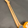 Maple guitar neck with skunk stripe and vintage tuners on honey blonde electric guitar body against gray background
