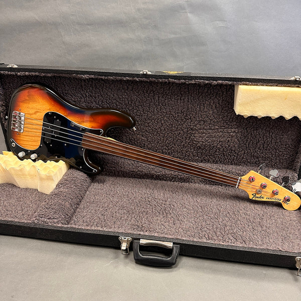 Fender Precision Bass guitar with sunburst finish and maple fretless neck in black padded hard case