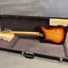 Sunburst electric bass guitar back view with maple neck inside black hard shell case with plush interior lining