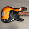 Sunburst electric bass guitar with black pickguard and two control knobs on gray background