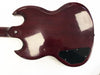 Back of vintage solid body electric guitar with dark reddish-brown finish and black plastic control cavity cover