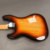 Electric guitar back body with sunburst finish and natural wood grain visible, metal neck plate, light-colored neck against gray background