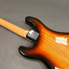 Back view of sunburst electric guitar body and maple neck with metal neck plate on gray background