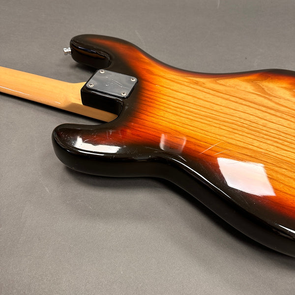 Close-up of sunburst finish electric guitar body with maple neck and metal neck plate on gray background