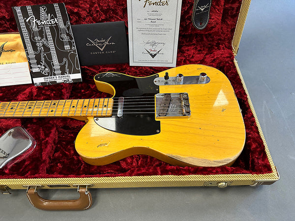 1960s Fender Telecaster electric guitar with maple neck and black pickguard in vintage tweed case with red plush interior, showing Fender certificate and owner's manual