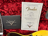 Fender Custom Shop Certificate of Authenticity for 1951 Nocaster Relic guitar with Custom Care booklet on red plush background and partial view of yellow relic guitar body