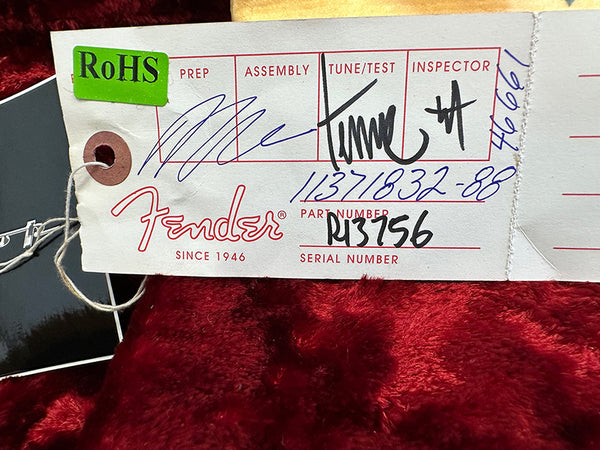 Fender guitar production tag showing RoHS compliance, handwritten prep, assembly, tune/test, and inspector signatures, part number R13756, serial number 11371832-88, on red plush background