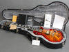 Gibson Les Paul electric guitar with sunburst finish in open hard case with warranty and owner’s manual documents
