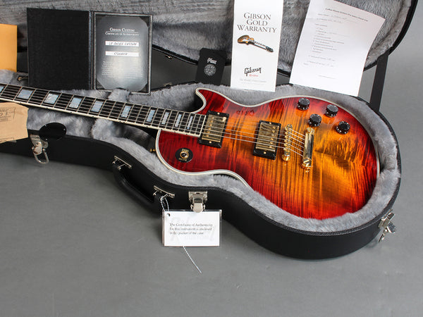 Gibson Les Paul electric guitar in sunburst finish with certificate of authenticity, Gibson Gold Warranty booklet, and original hard case with plush interior from Coffee House Guitars.