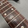 Close-up of guitar fretboard showing mother-of-pearl inlays and metal frets on rosewood fingerboard with steel strings at Coffee House Guitars.