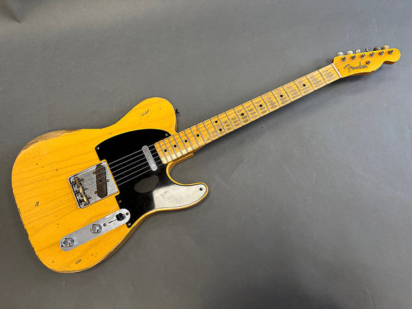 Vintage Fender Telecaster electric guitar with natural wood finish and maple fretboard on gray background