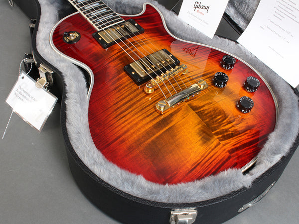 Gibson Les Paul electric guitar with sunburst finish in a plush-lined hard case, showing gold hardware and black control knobs.