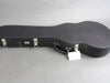 Hard shell black guitar case with metal latches and handle on gray background, suitable for acoustic guitars