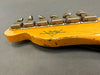 Close-up of vintage Fender Custom Shop guitar headstock with aged tuning pegs and worn wood finish on gray background