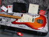 Fender electric guitar in sunburst finish with maple neck, white pearloid pickguard, and P90 pickups in black hard case with accessories and certificate of authenticity.