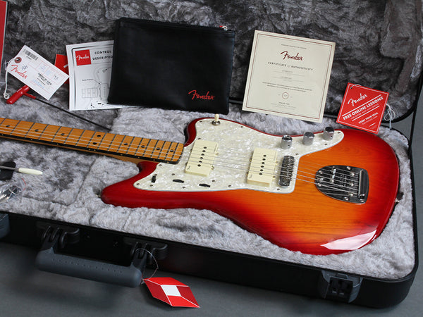 Fender electric guitar in sunburst finish with maple neck, white pearloid pickguard, and P90 pickups in black hard case with accessories and certificate of authenticity.