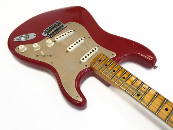 Red electric guitar with maple neck, vintage-style pickups, and cream pickguard on white background