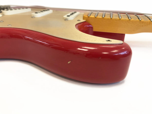 Close-up of red electric guitar body with cream pickguard and maple neck showing a small chip in the finish, ideal for guitar listings at Coffee House Guitars.