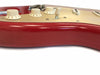 Close-up view of red electric guitar body with cream control knobs for tone and volume and three single-coil pickups on white pickguard
