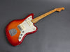 Electric guitar with sunburst finish and maple neck on gray background, vintage-style pickups and white pearloid pickguard