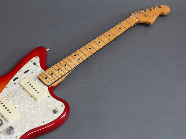 Fender electric guitar with red sunburst body, maple neck, pearl white pickguard, and dual single-coil pickups on gray background