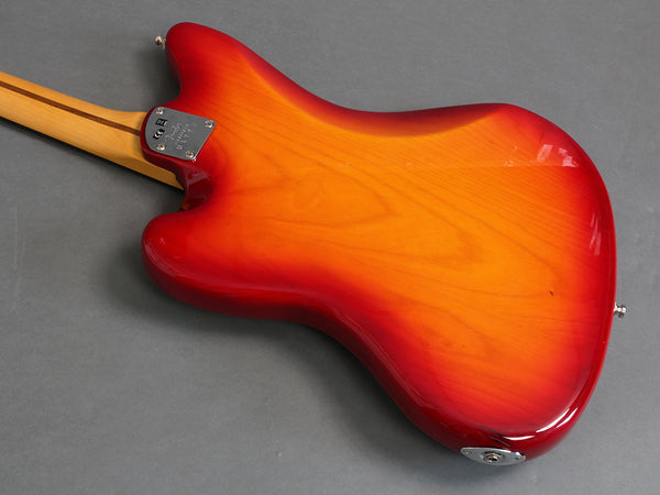 Back view of sunburst electric guitar body with maple neck and metal neck plate on gray background