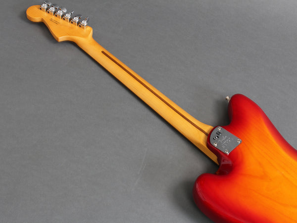 Back view of electric guitar with sunburst finish and maple neck on gray background