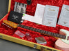 Fender pink electric guitar neck and headstock in yellow tweed hard case with red plush lining, Fender Custom Care booklet, certificate of authenticity, pre-sale checklist, small plastic bags with parts, guitar picks, and chrome tremolo cover plate.
