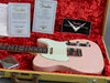 Fender Custom Shop pink telecaster guitar with white pickguard resting in vintage tweed hardshell case with red plush interior, accompanied by Fender Custom Shop certificates of authenticity and logo sticker.