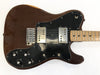 Vintage electric guitar with brown body, black pickguard, dual humbucker pickups, maple fretboard, and four control knobs on a white background