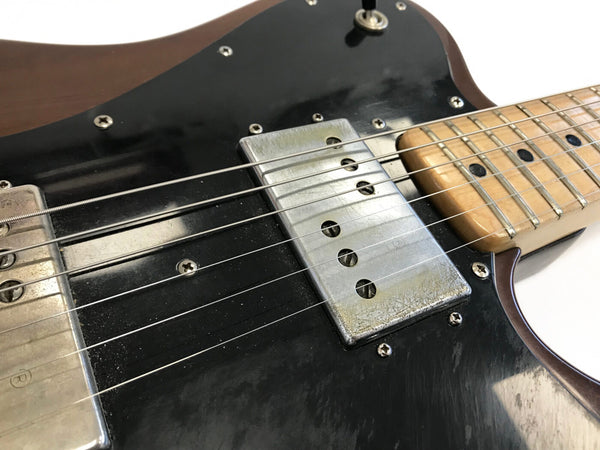 Close-up of electric guitar with black pickguard, silver pickups, maple fretboard, and six strings at Coffee House Guitars product listing