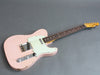 Vintage pink electric guitar with single cutaway body and white pickguard on gray background