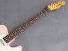 Close-up of Fender Telecaster electric guitar neck with rosewood fretboard and maple headstock on gray background