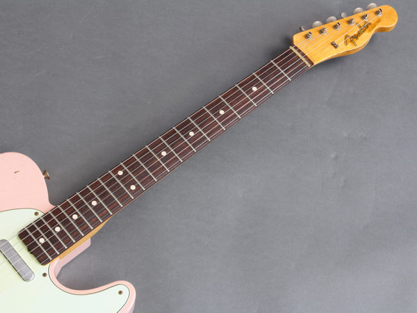 Close-up of Fender Telecaster electric guitar neck with rosewood fretboard and maple headstock on gray background