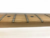 Close-up of maple guitar neck fretboard with metal frets and black dot inlays, six steel guitar strings against white background