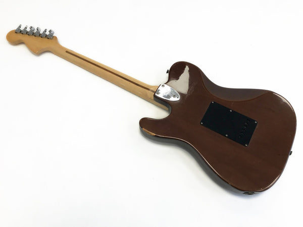 Brown electric guitar back with maple neck and chrome tuning pegs on white background, showing black plastic cover plate on body and neck joint plate screws.
