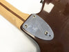 Close-up of Fender guitar neck plate with Micro-Neck Adjust system on brown guitar body and maple neck with walnut stripe