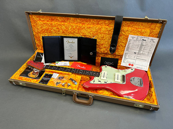 Vintage Fender electric guitar in pink with cream pickguard and P90 pickups in open orange velvet-lined brown hard case with accessories and documentation