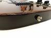 Close-up of a dark glossy electric guitar body showing a strap button and a small area of damage on the side edge with guitar bridge and control knobs in soft focus
