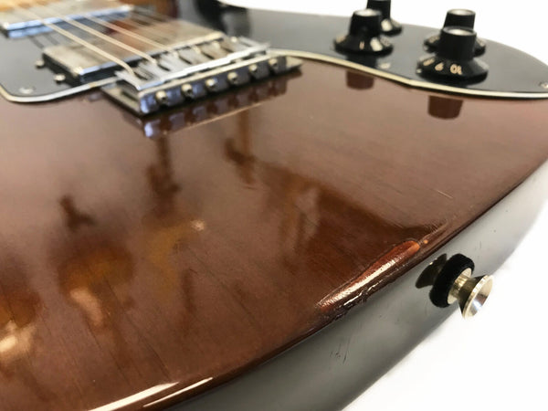 Close-up of brown electric guitar body showing finish wear and control knobs at Coffee House Guitars product listing