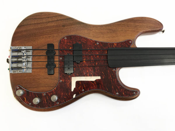 Fretless electric bass guitar with natural wood finish and tortoiseshell pickguard on white background