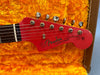 Close-up of red Fender Jazzmaster guitar headstock with tuning pegs inside orange plush case for sale at Coffee House Guitars