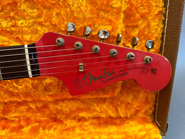 Close-up of red Fender Jazzmaster guitar headstock with tuning pegs inside orange plush case for sale at Coffee House Guitars