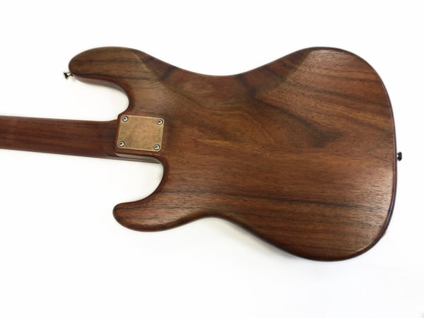 Back view of electric guitar body made of polished dark wood with metal neck plate and screws, isolated on white background