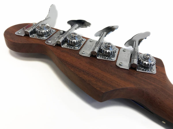 Close-up of bass guitar headstock with four chrome tuning pegs on a dark wood finish against a white background